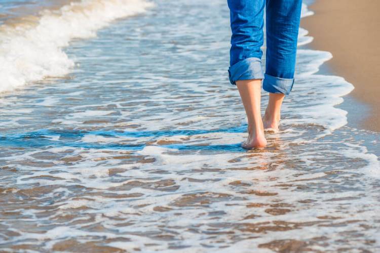 person walking along beach in the water