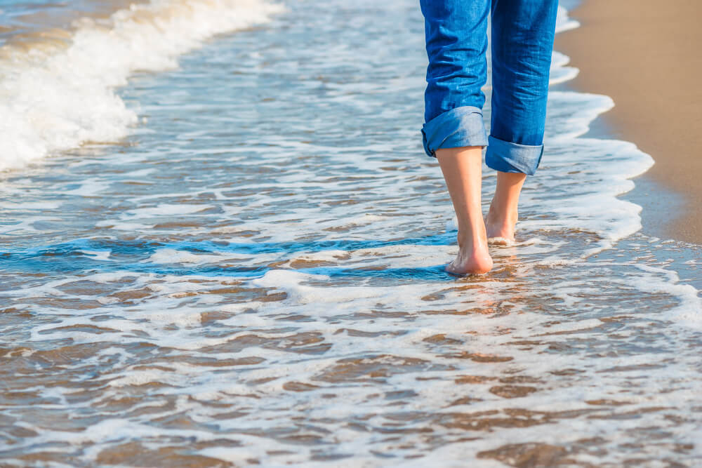 A person walking along the beach in Emerald Isle during low tide.